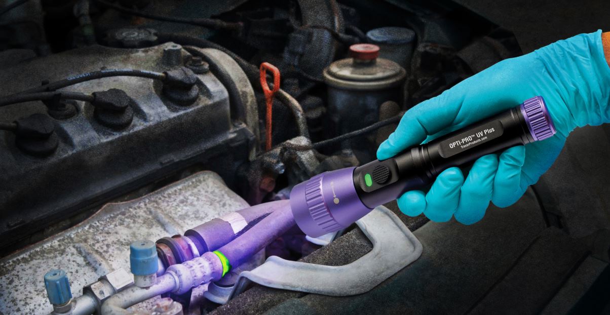 ac leak tracer Technician using UV light to detect A/C refrigerant leak in hybrid vehicle